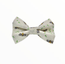 Handmade dog bow tie in cotton print. Made by hand in the U.K. and washable. Cream cotton dotted with tiny bees and flowers.