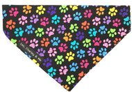 Rainbow paw print dog bandana with black background and purple velvet lining.