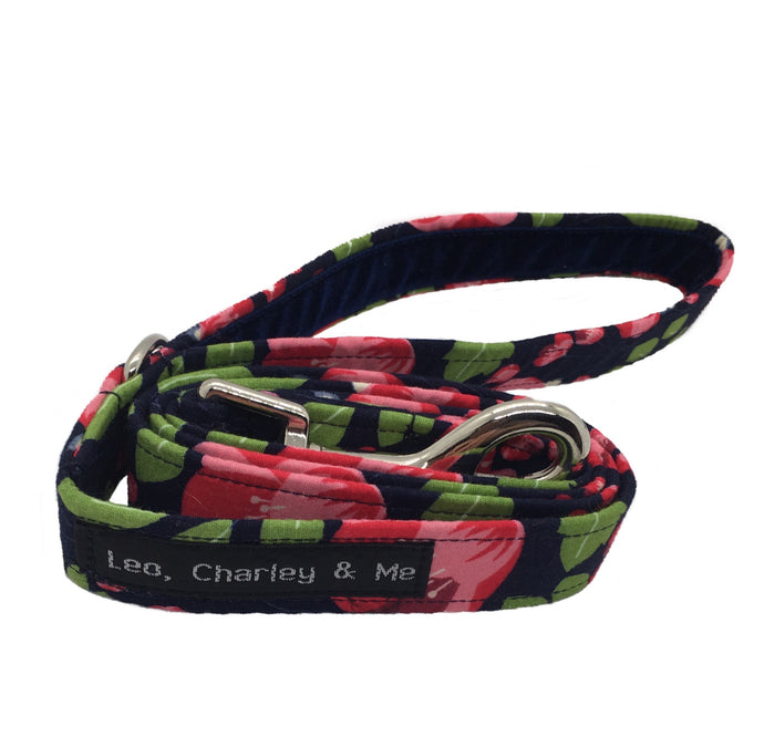 Soft cotton poplin dog lead with pink fuchsias and green foliage on a navy background. It has a soft navy velvet ribbon lined handle. Hand made in the U.K. and washable.