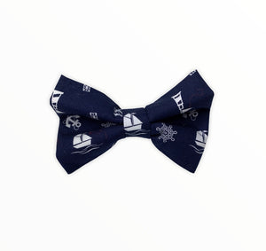 Handmade dog bow tie in cotton print. Made by hand in the U.K. and washable. Navy cotton poplin with nautical symbols and boats. 