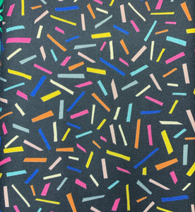 Confetti print fabric with multicoloured strands on a navy background 