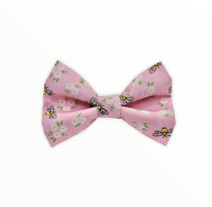 Handmade dog bow tie in cotton print. Made by hand in the U.K. and washable. Pale pink with tiny bees and flowers printed on it. 