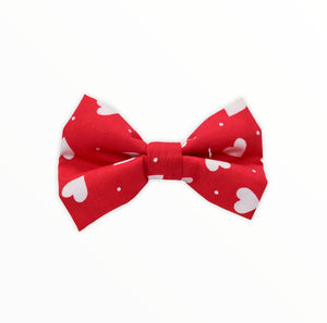 Handmade dog bow tie in cotton print. Made by hand in the U.K. and washable. Valentines bow in red with tiny white hearts. 