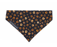 Handmade cotton poplin dog bandana in Muddy Paws print on a black back ground. Handmade in the UK and washable. Matching accessories available.